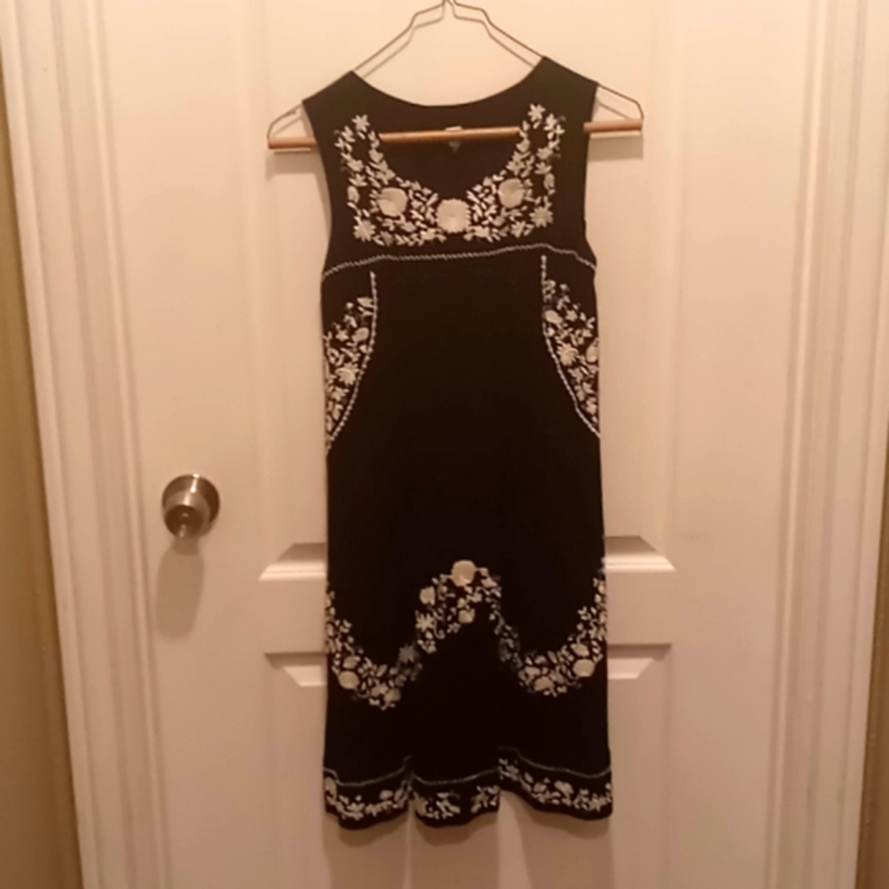 Black dress with white floral embroidery.